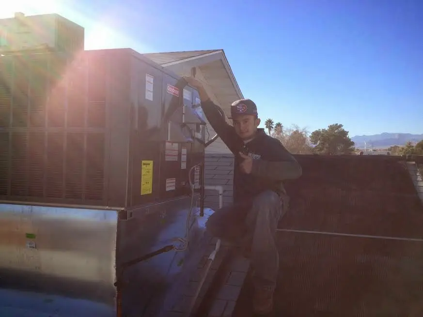 HVAC technician performing AC Tune-Up on a rooftop unit in South Hanover
